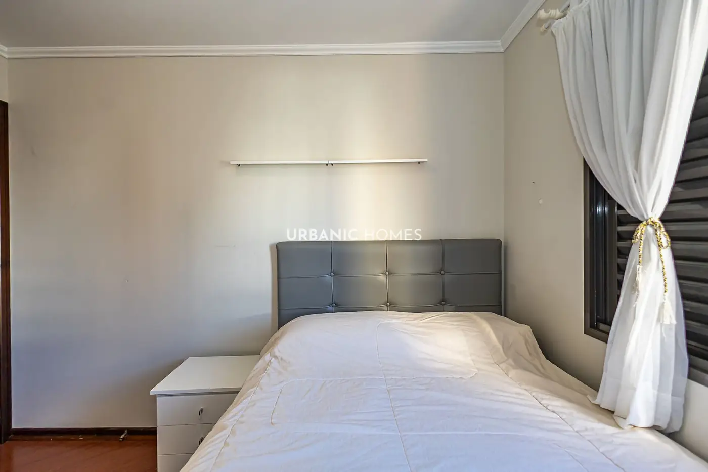 Quarto com cabeceira cinza e cortina