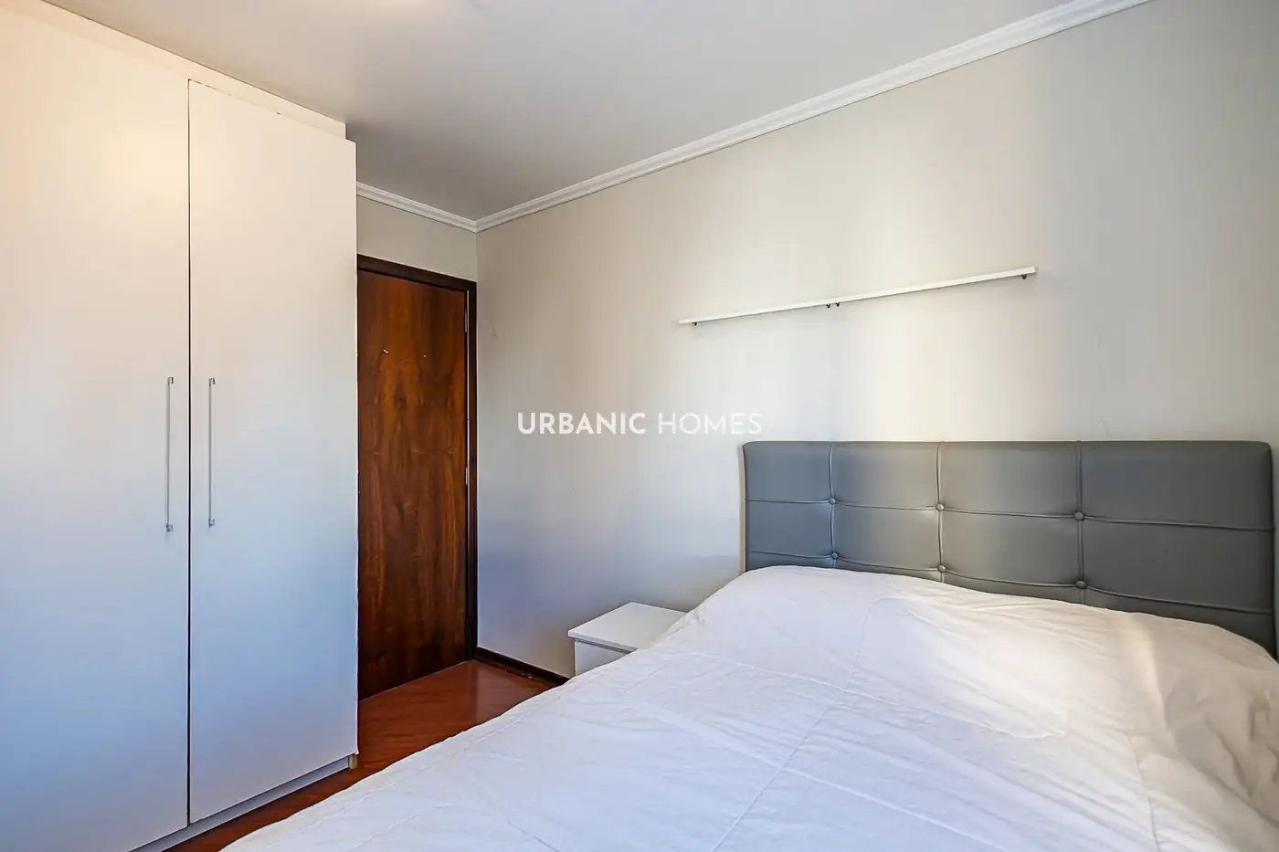 Quarto com guarda-roupa branco de duas portas
